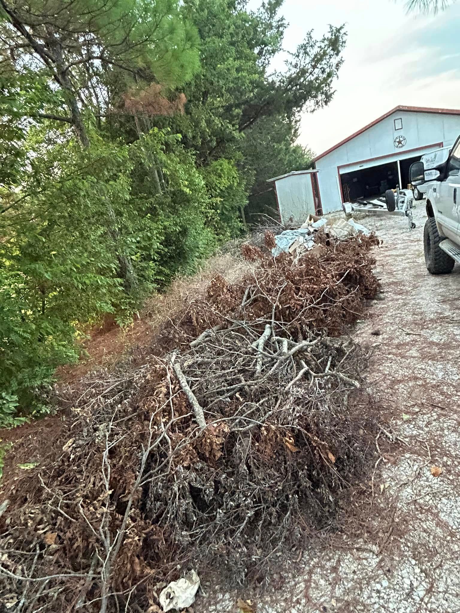 A truck is parked in front of a pile of branches.