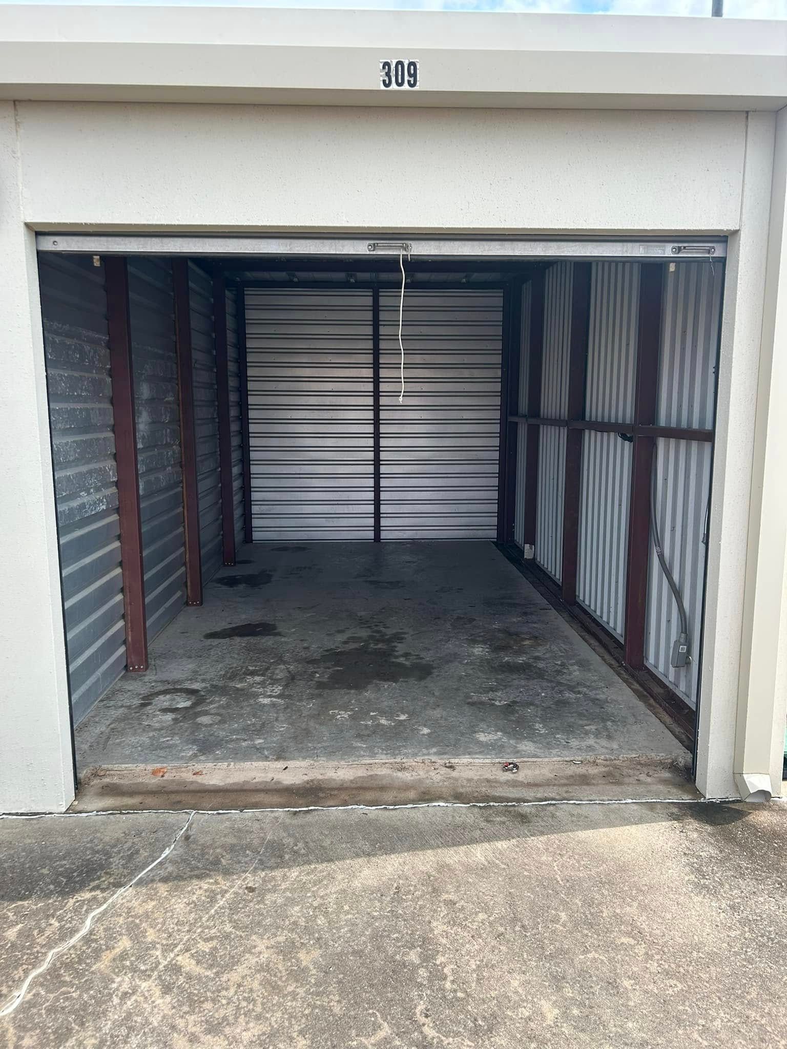 A small empty garage with the door open.