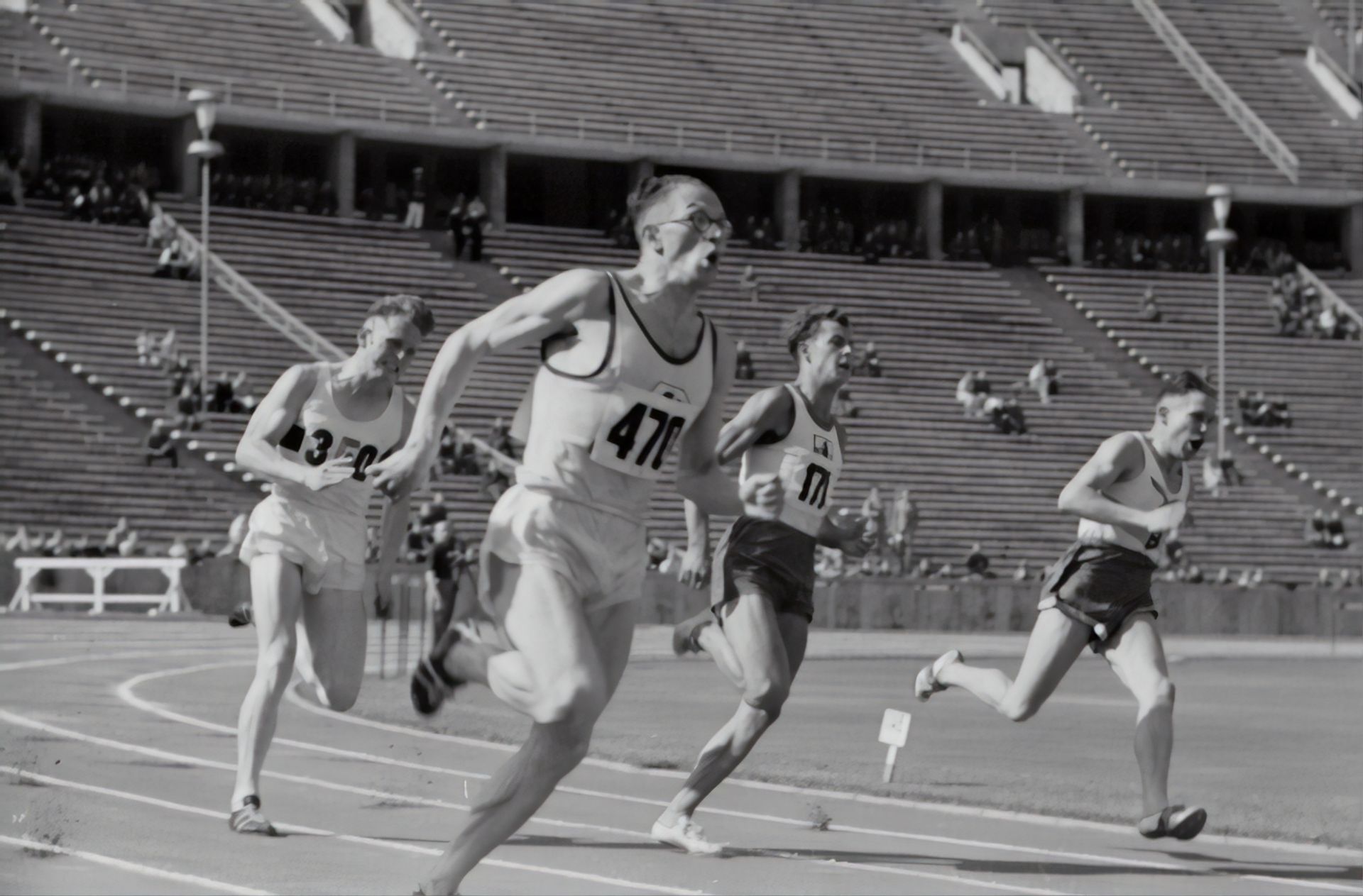 A group of men are running on a track and one of them has the number 47 on his shirt