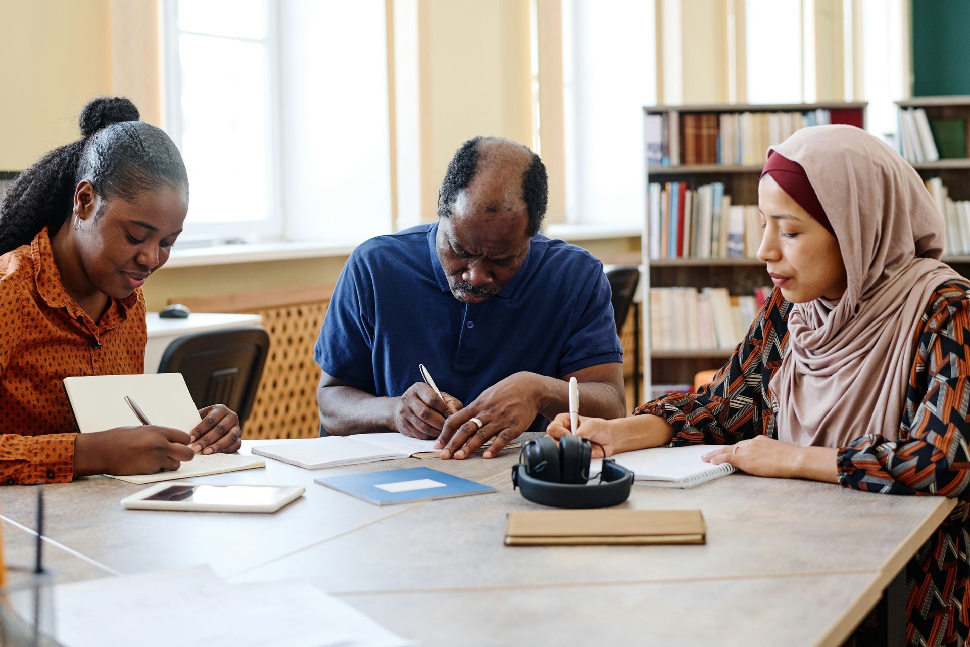 A group of people are sitting at a table in a library.