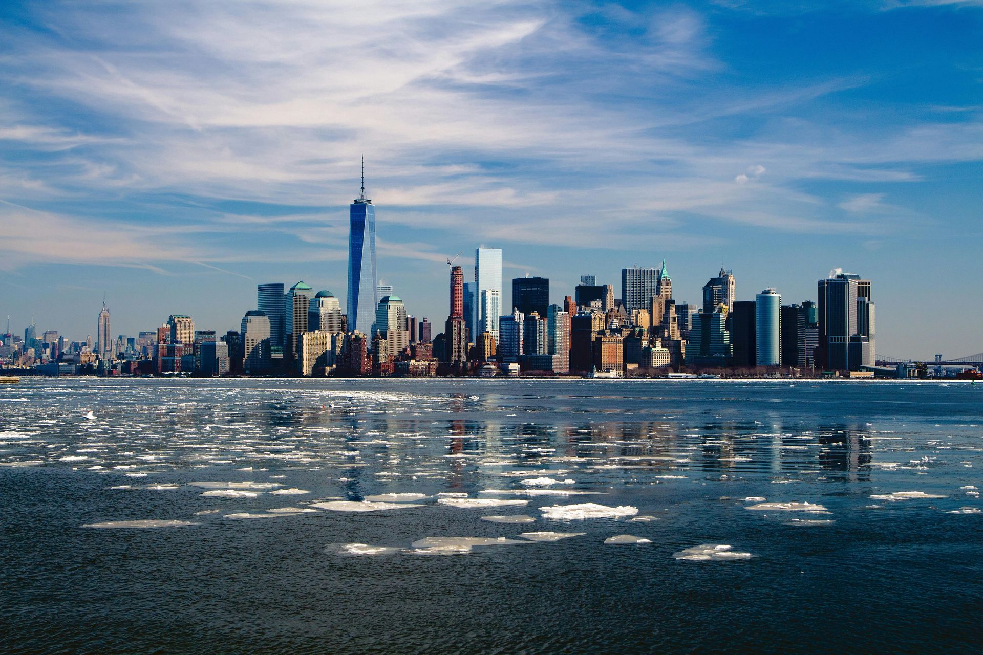 The skyline of new york city is reflected in the water