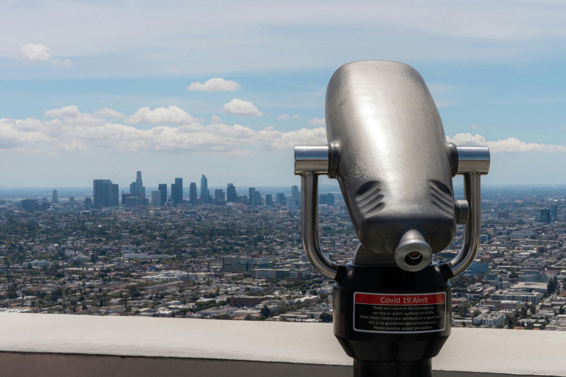 A coin operated binoculars looking out over a city