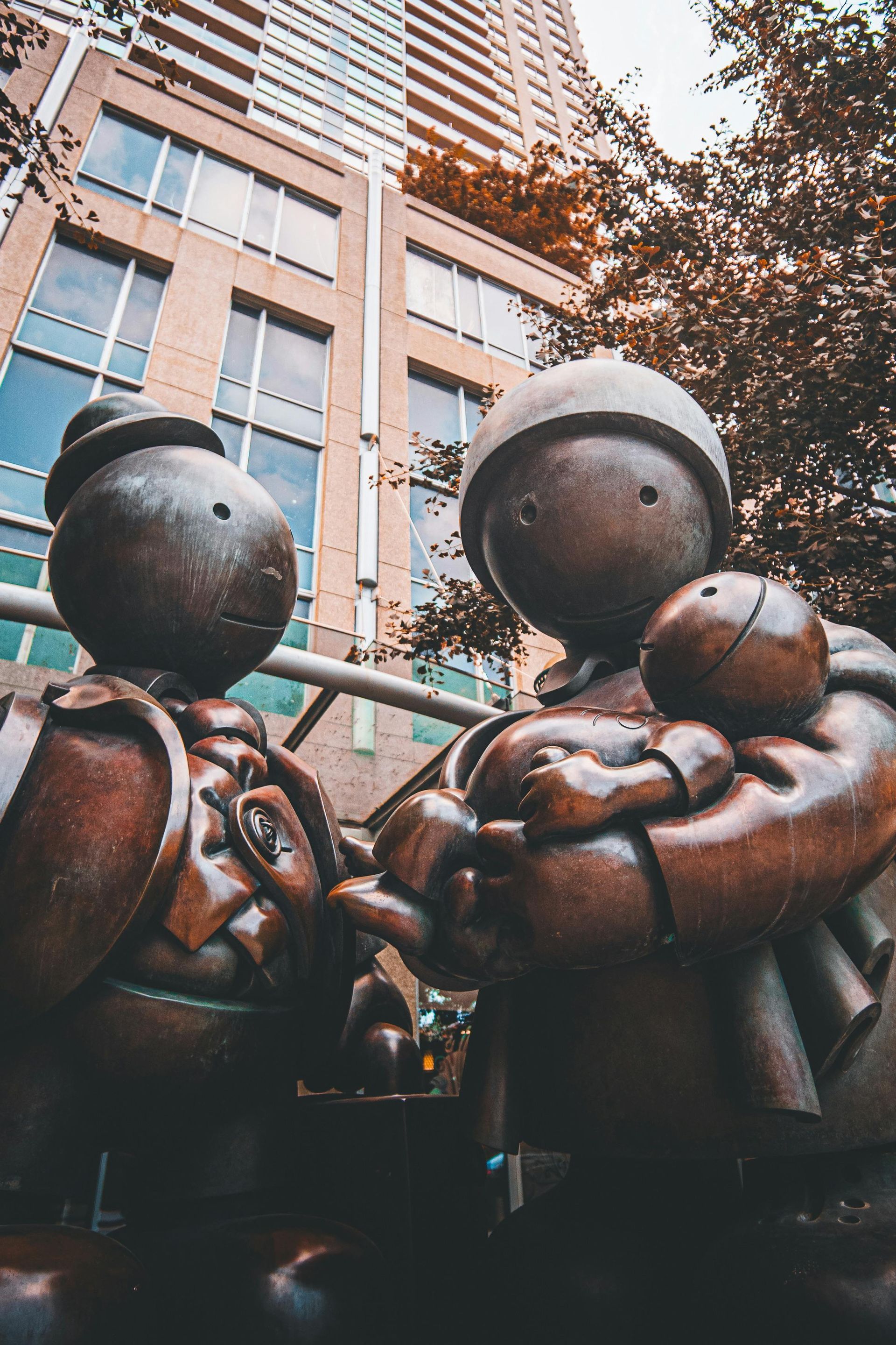 A statue of a man and woman holding a baby in front of a building.