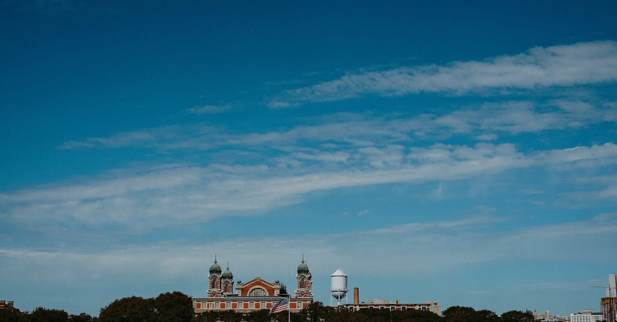 A large building with a blue sky and clouds in the background.