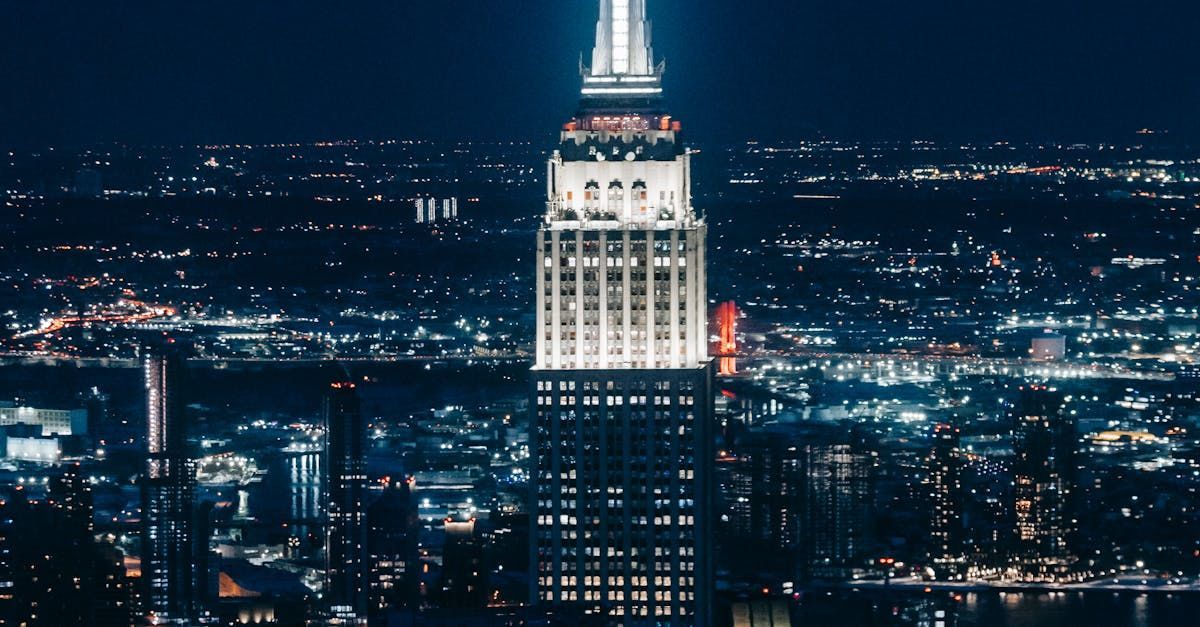 The empire state building is lit up at night in new york city.