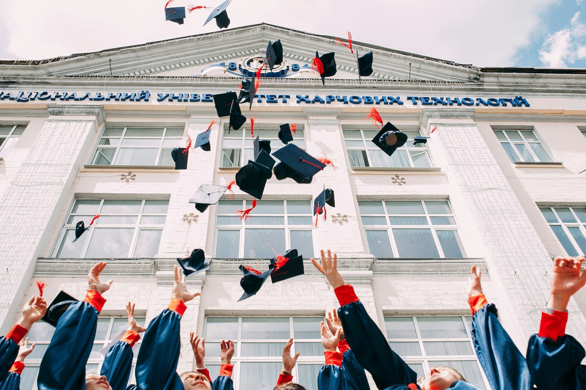 A group of graduates are throwing their graduation caps in the air.