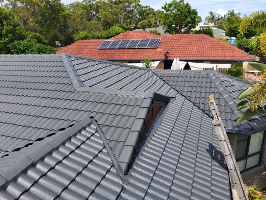 House With a Tiled Roof and Solar Panels on the Roof — Above All Roof Painters & Repairs in Bellmere, QLD