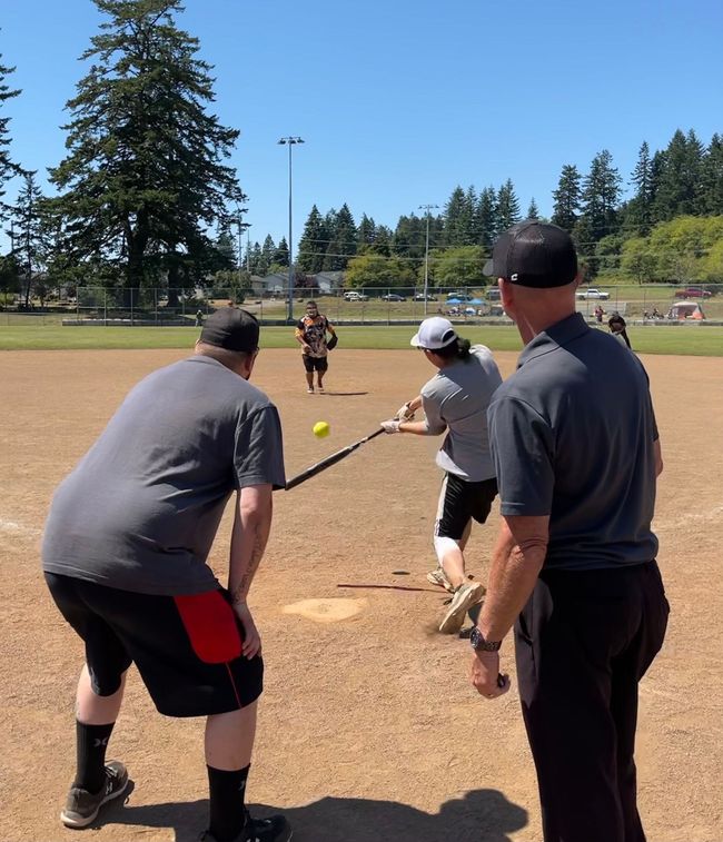 A group of people are playing a game of softball