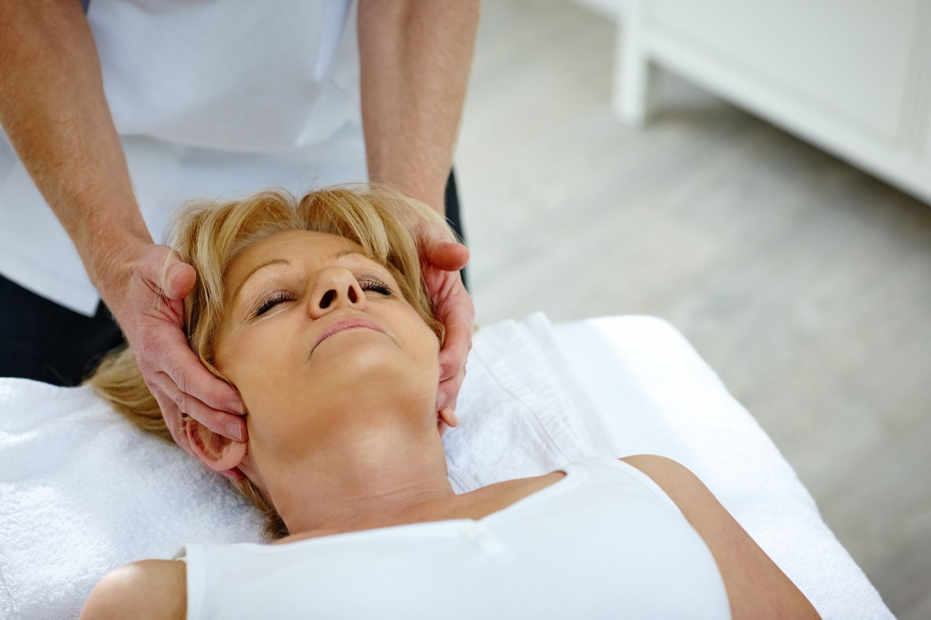Woman is lying on a Bed getting a Massage from a Chiropractor - Terre Haute, IN - Advanced Chiropractic Center