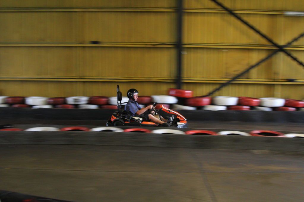 A man is riding a go kart on a track.