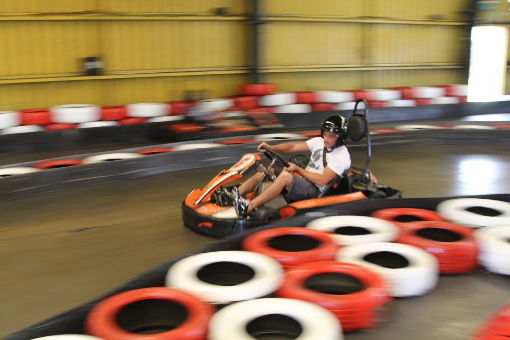 A man is driving a go kart on a track