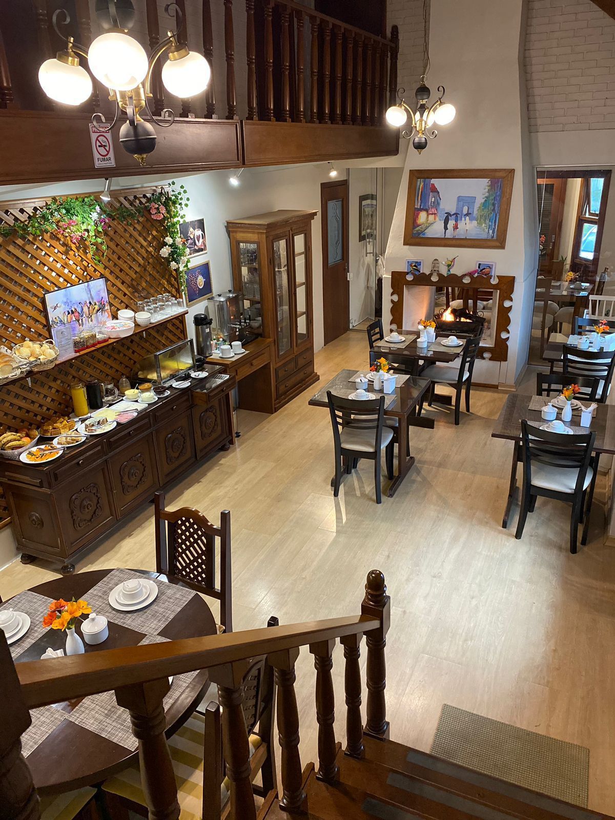 Buffet de café da manhã em uma sala de jantar de dois andares com móveis de madeira e lareira.