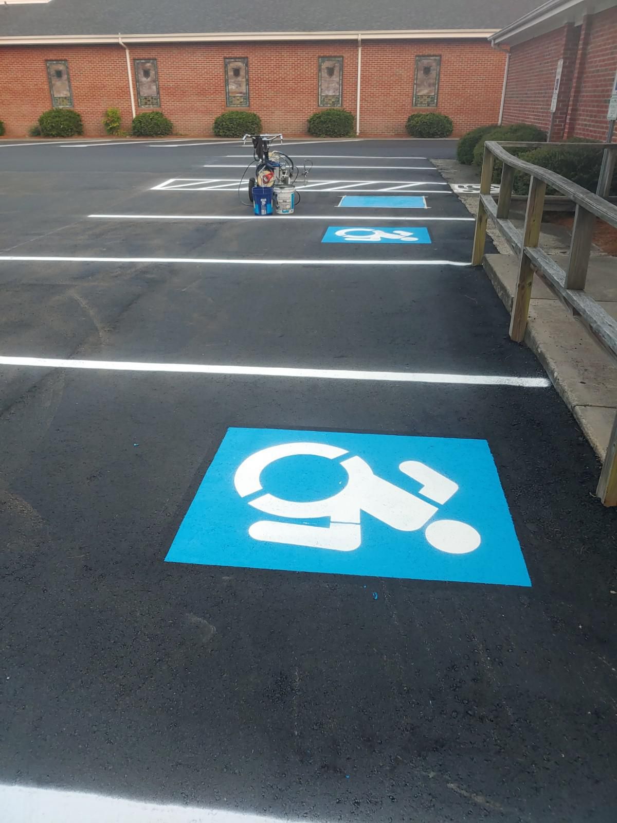 Parking lot with several blue and white handicap parking spaces.