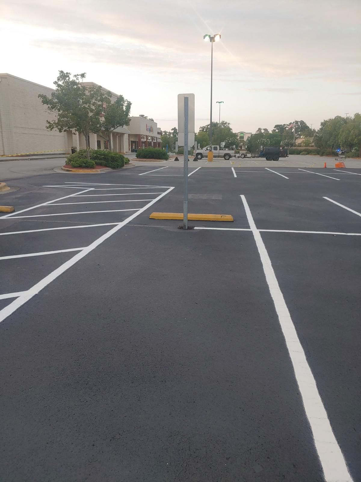 Newly painted parking lot with white lines, and a sign.