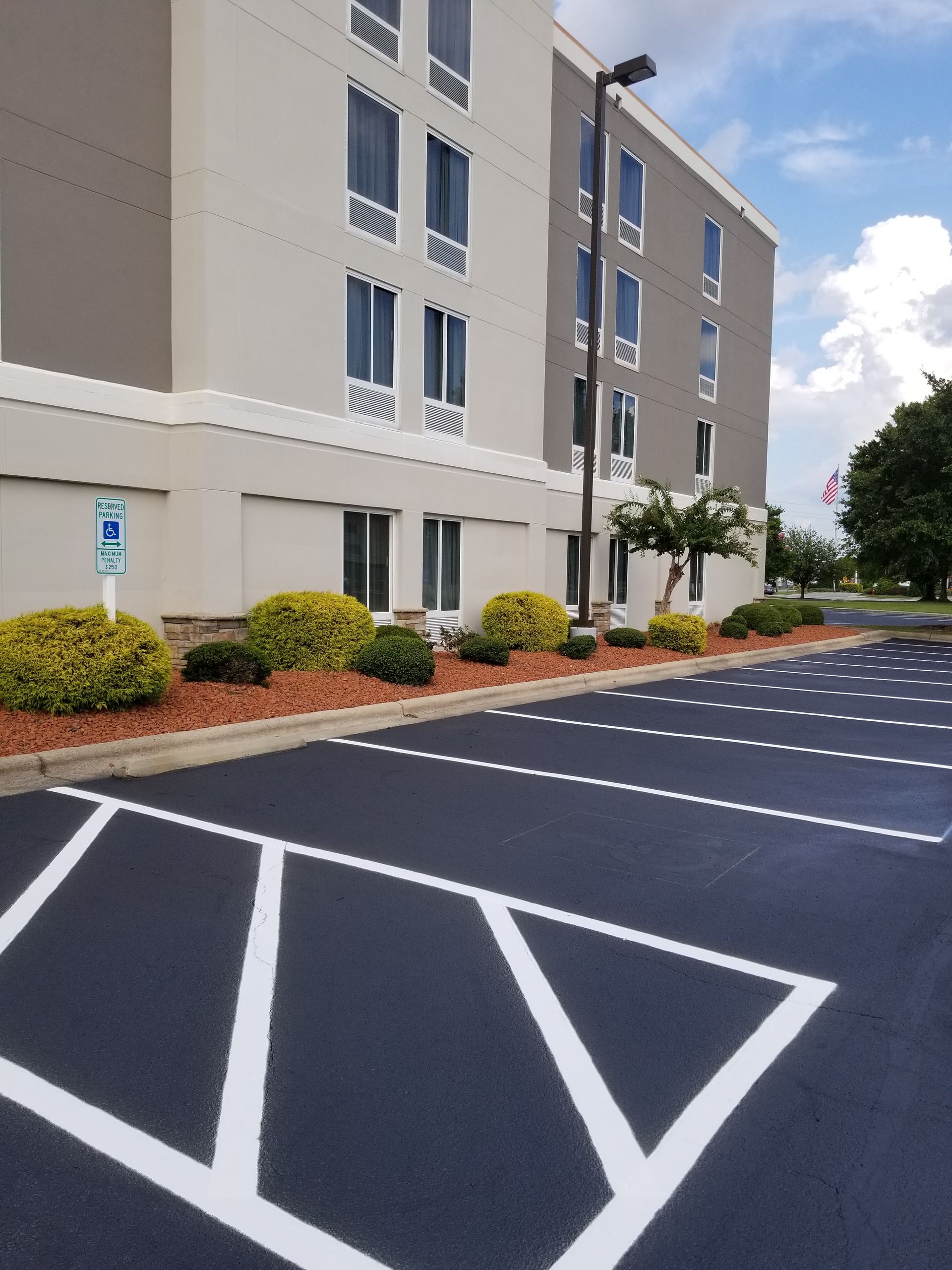 Hotel exterior with parking spaces, including a handicap accessible spot.