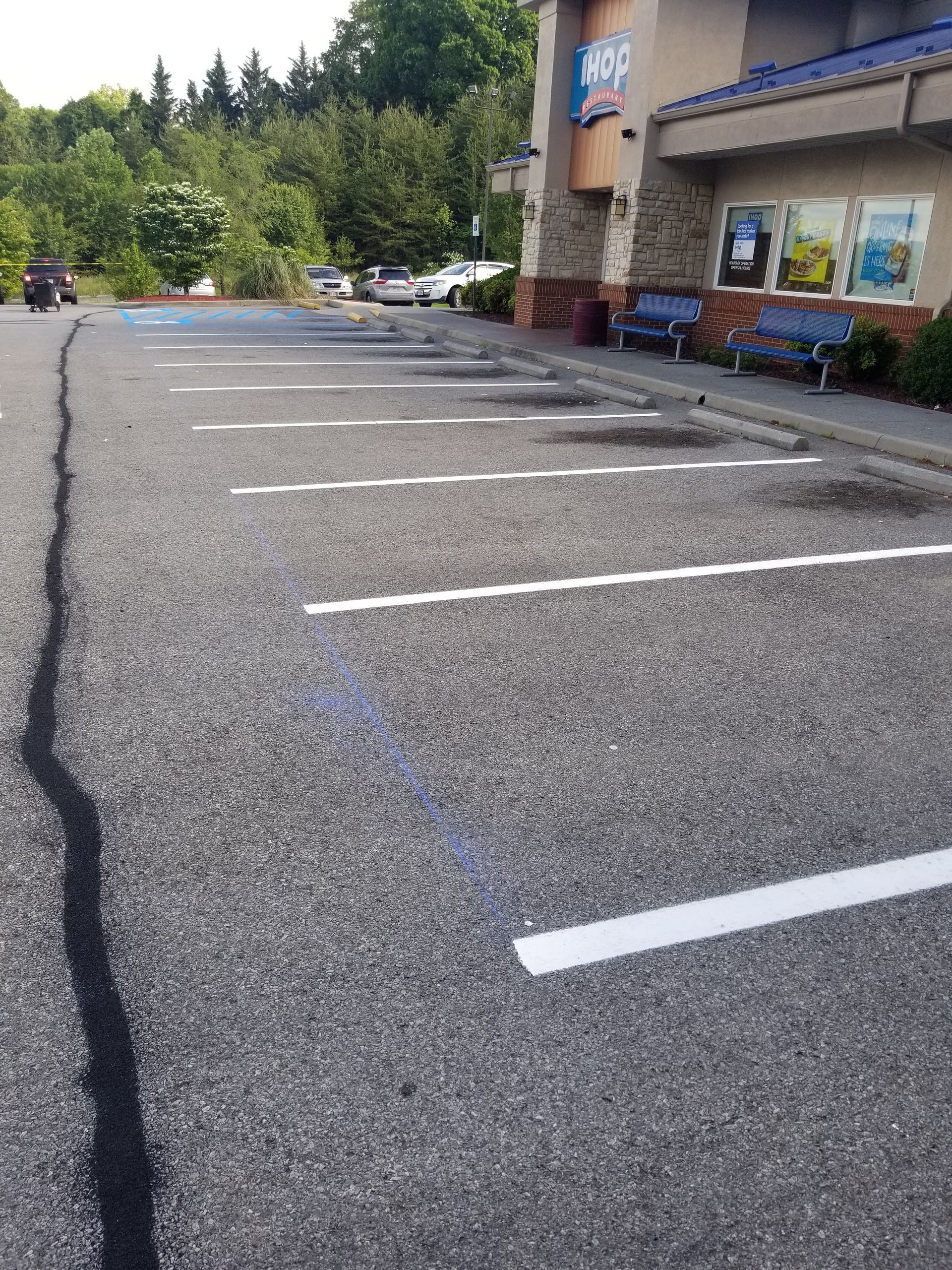 Parking lot with white painted spaces in front of a building with a blue awning.