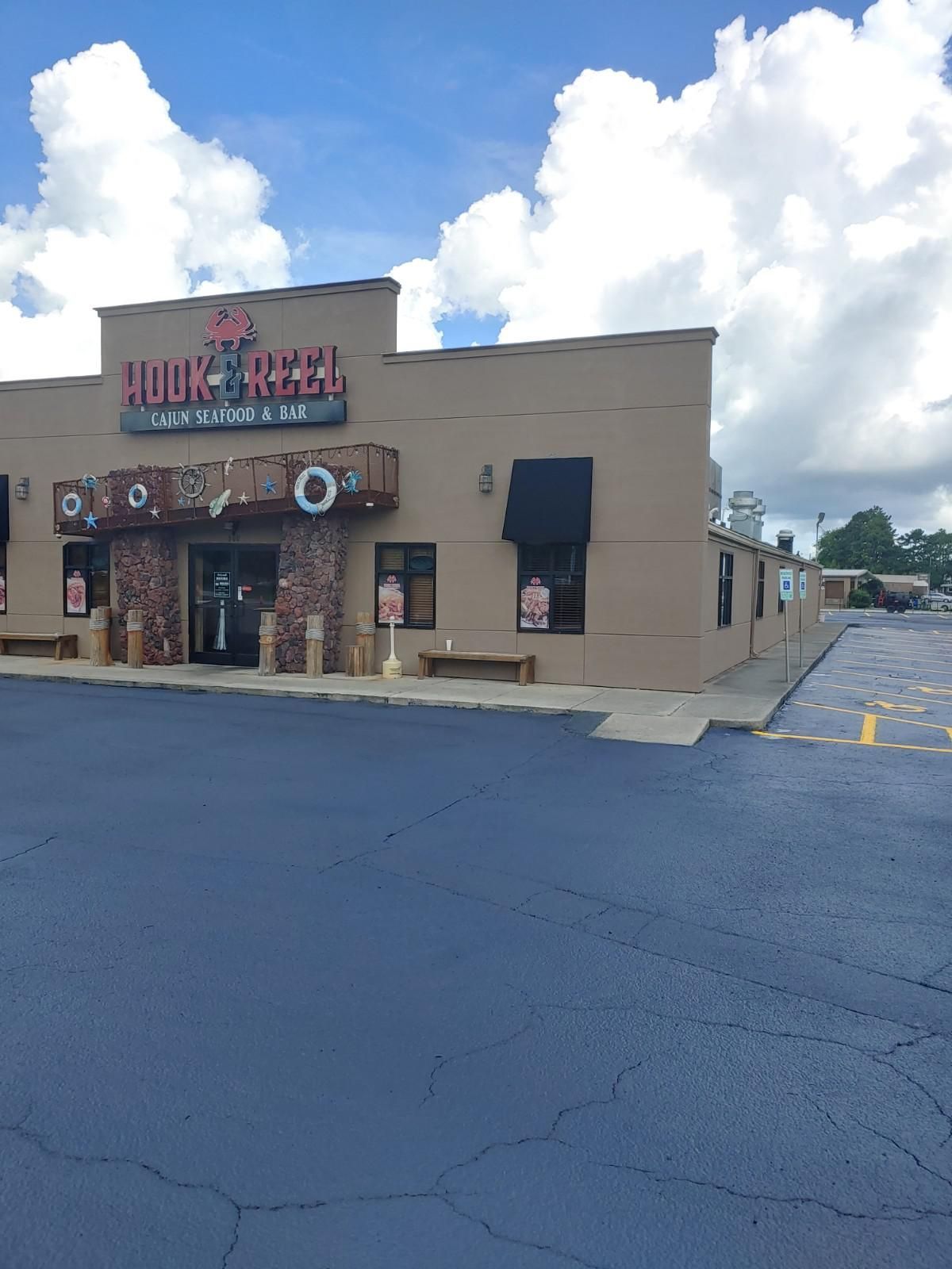 The Hook & Reel restaurant exterior, brown facade, blue sky, empty parking lot.