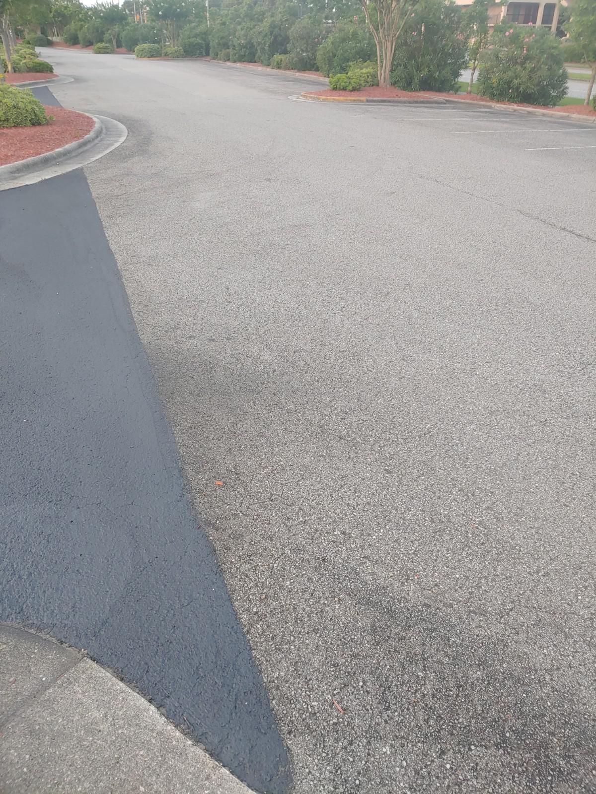 Asphalt road with fresh black asphalt alongside a gray pavement.