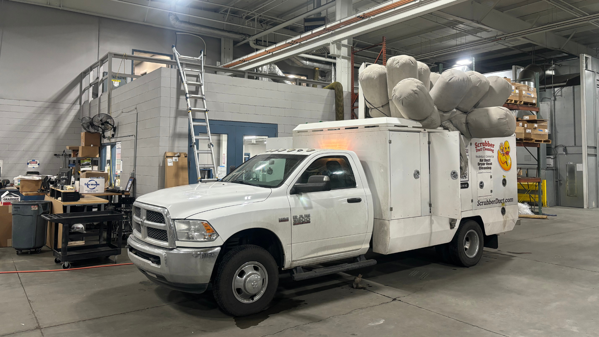 A man is standing in front of a blue and white truck.