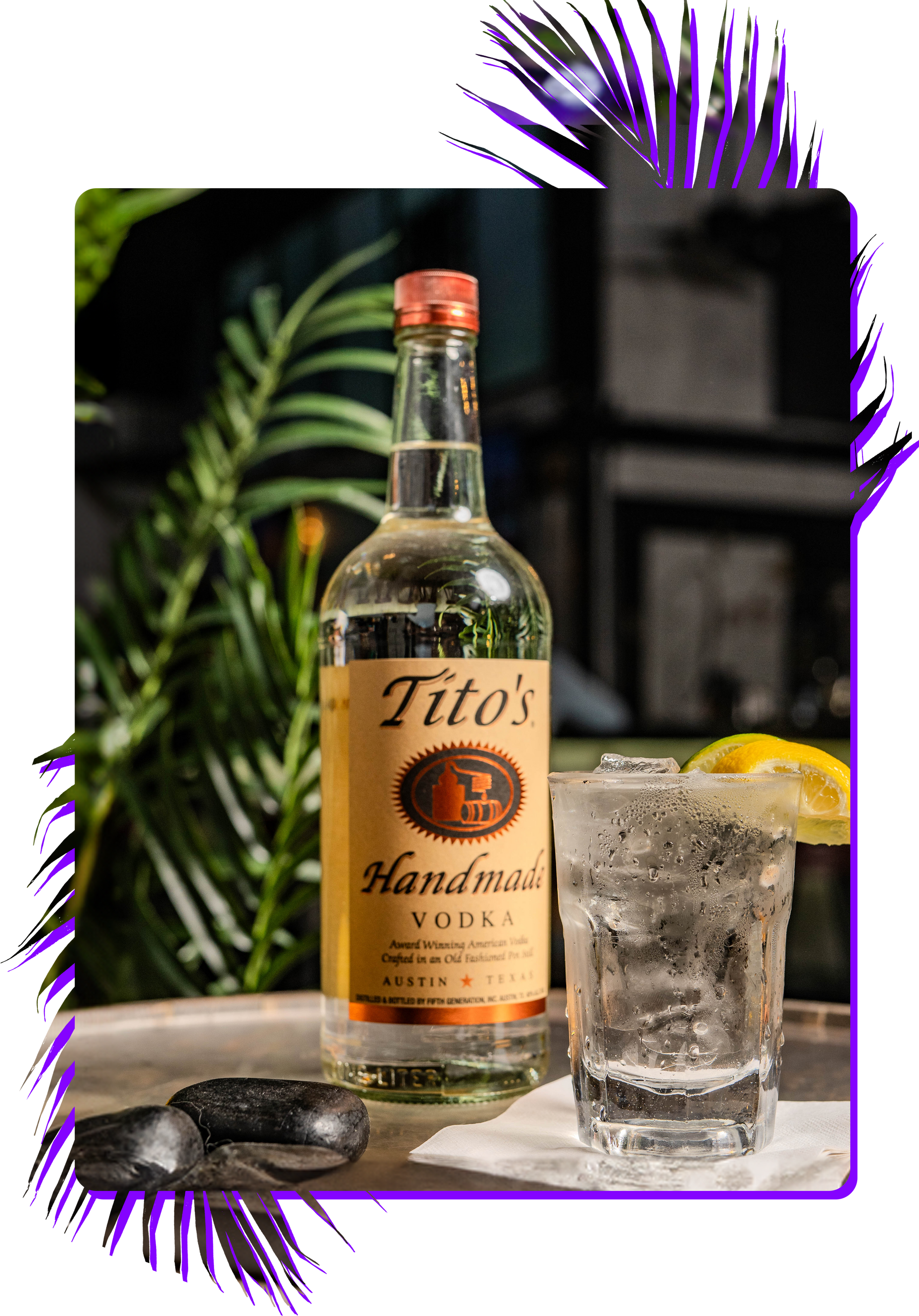 A bottle of tito 's vodka and a glass of vodka on a tray.