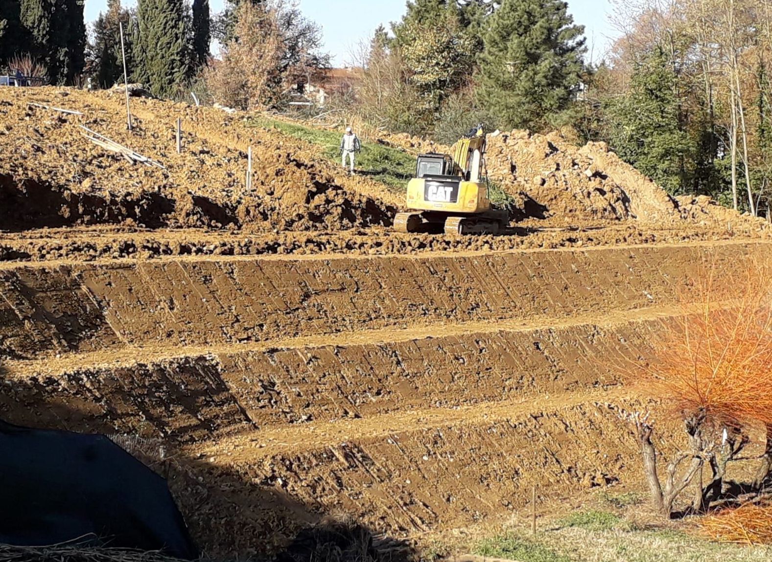 Un bulldozer sta scendendo da una collina sterrata.