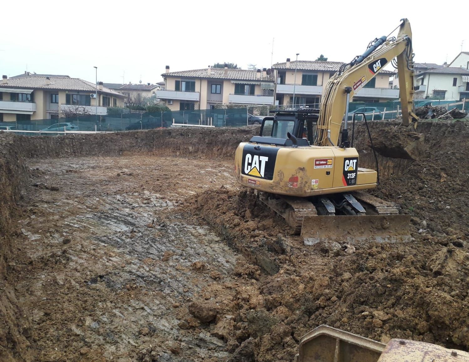 Un escavatore a gatto sta scavando una buca nel terreno