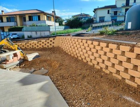 Un muro di mattoni viene costruito nel cortile di fronte a una casa.
