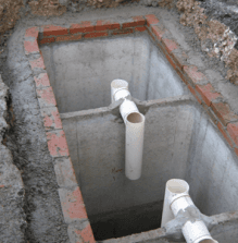 Un buco nel terreno da cui escono dei tubi