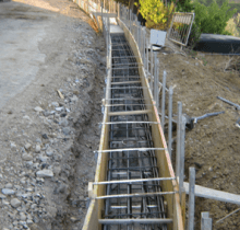 Un muro di cemento viene costruito sul ciglio di una strada