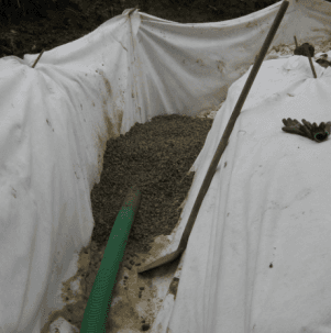 Un tubo verde viene utilizzato per pompare il calcestruzzo in un buco