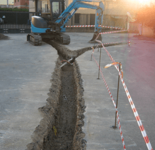 Un escavatore blu sta scavando una buca nel terreno