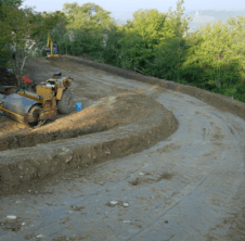 Una ruspa sta percorrendo una strada sterrata.