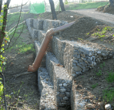 Un muro di pietra da cui sporge un tubo