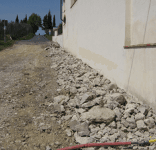 Un tubo è appoggiato su un mucchio di rocce vicino a un edificio