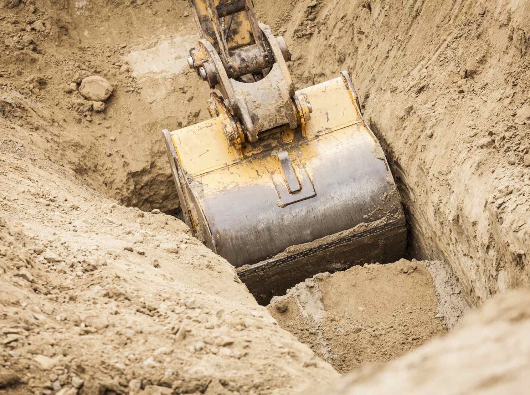 Una ruspa sta scavando una buca nel terreno.