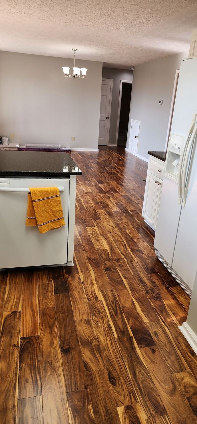 A kitchen with hardwood floors and white cabinets.