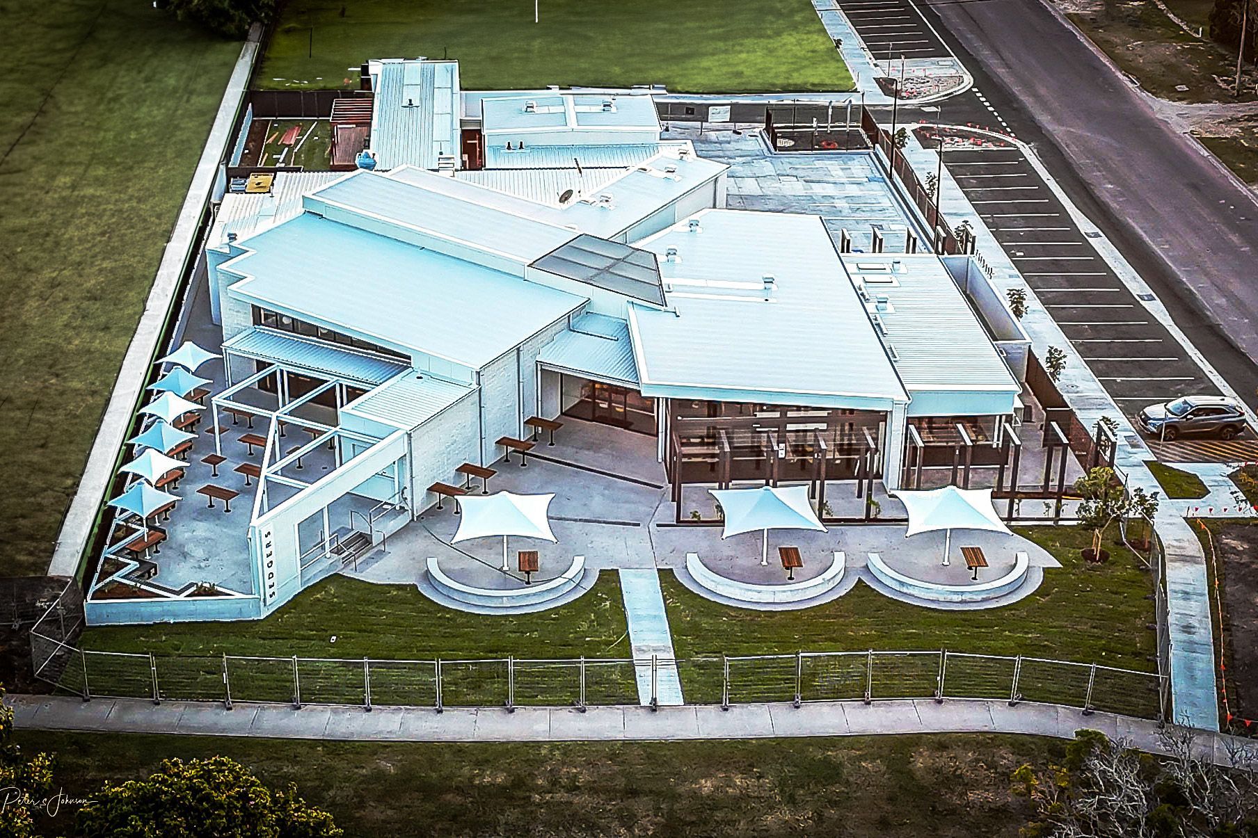 An aerial view of Sedgers Reef Hotel with umbrellas in front of it.