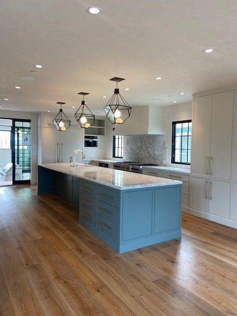 A kitchen with blue cabinets and white counter tops