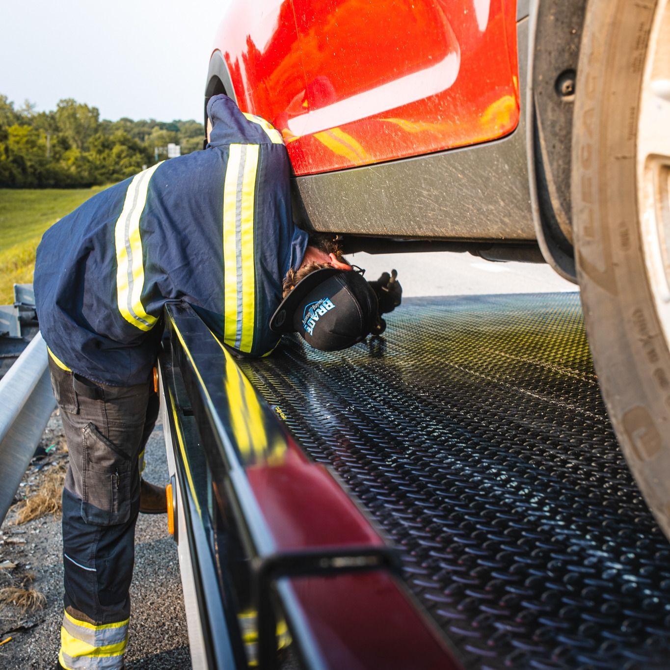 A tow truck is towing a car on a flatbed trailer.