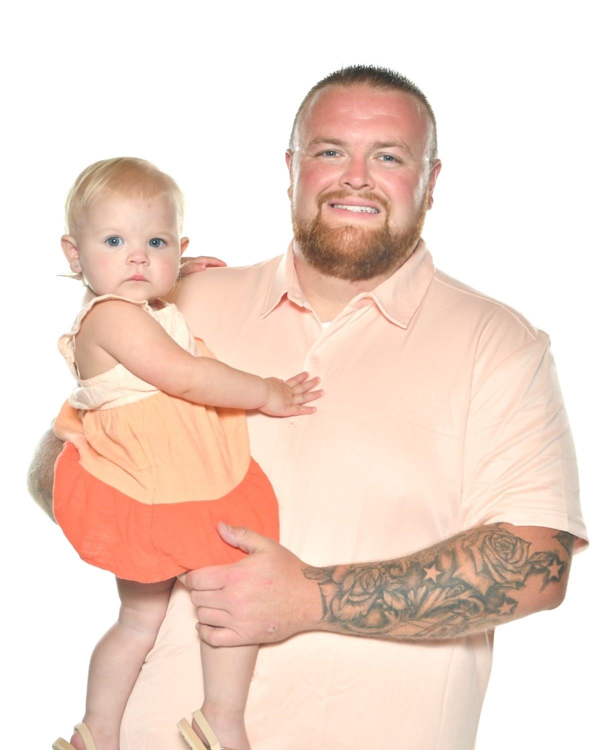 A man is holding a baby girl in his arms.