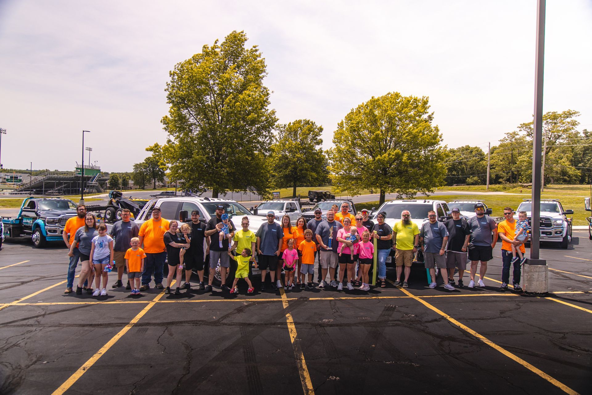 A group of people posing for a picture in a parking lot
