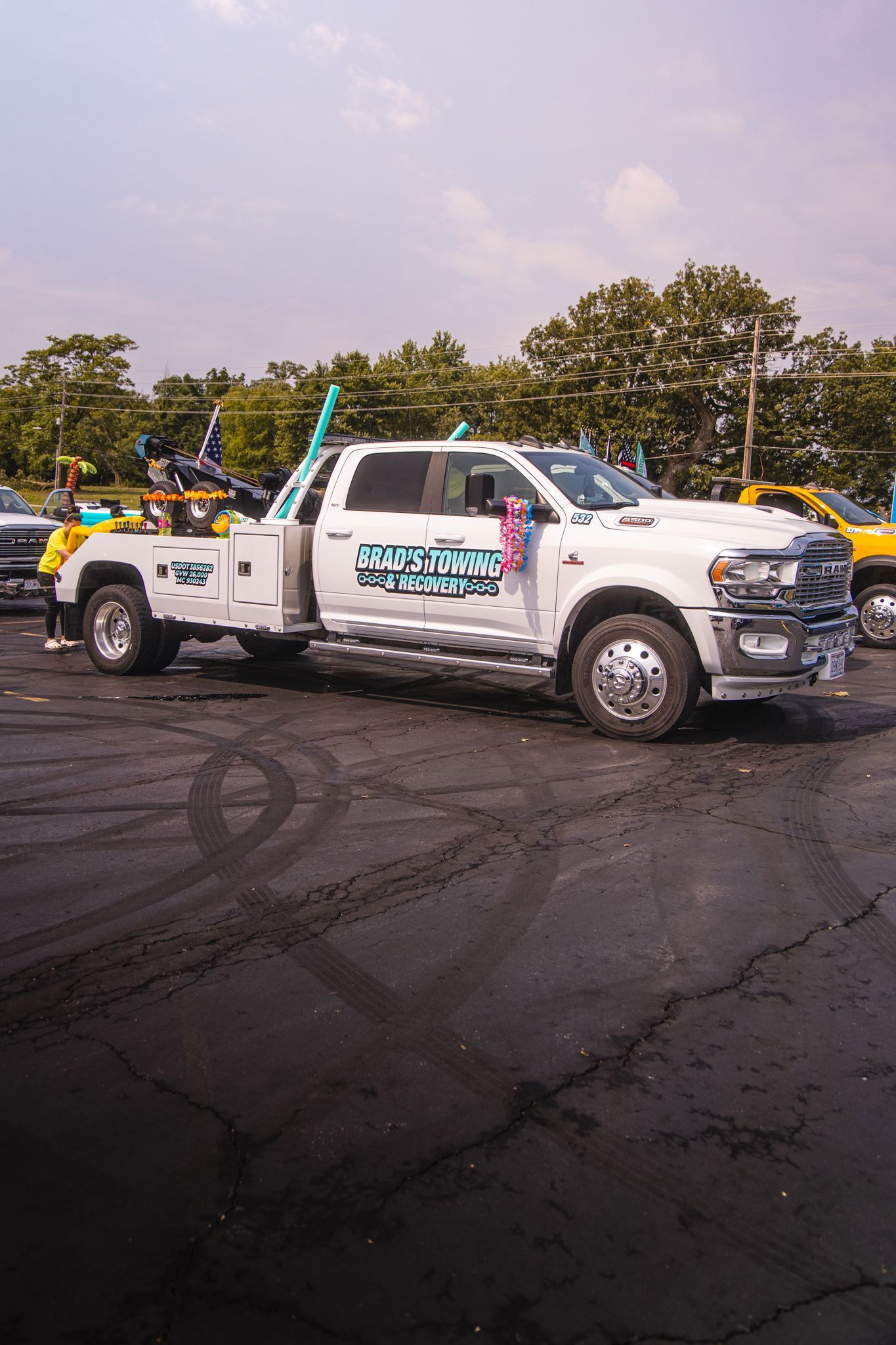 A white tow truck is parked in a parking lot.