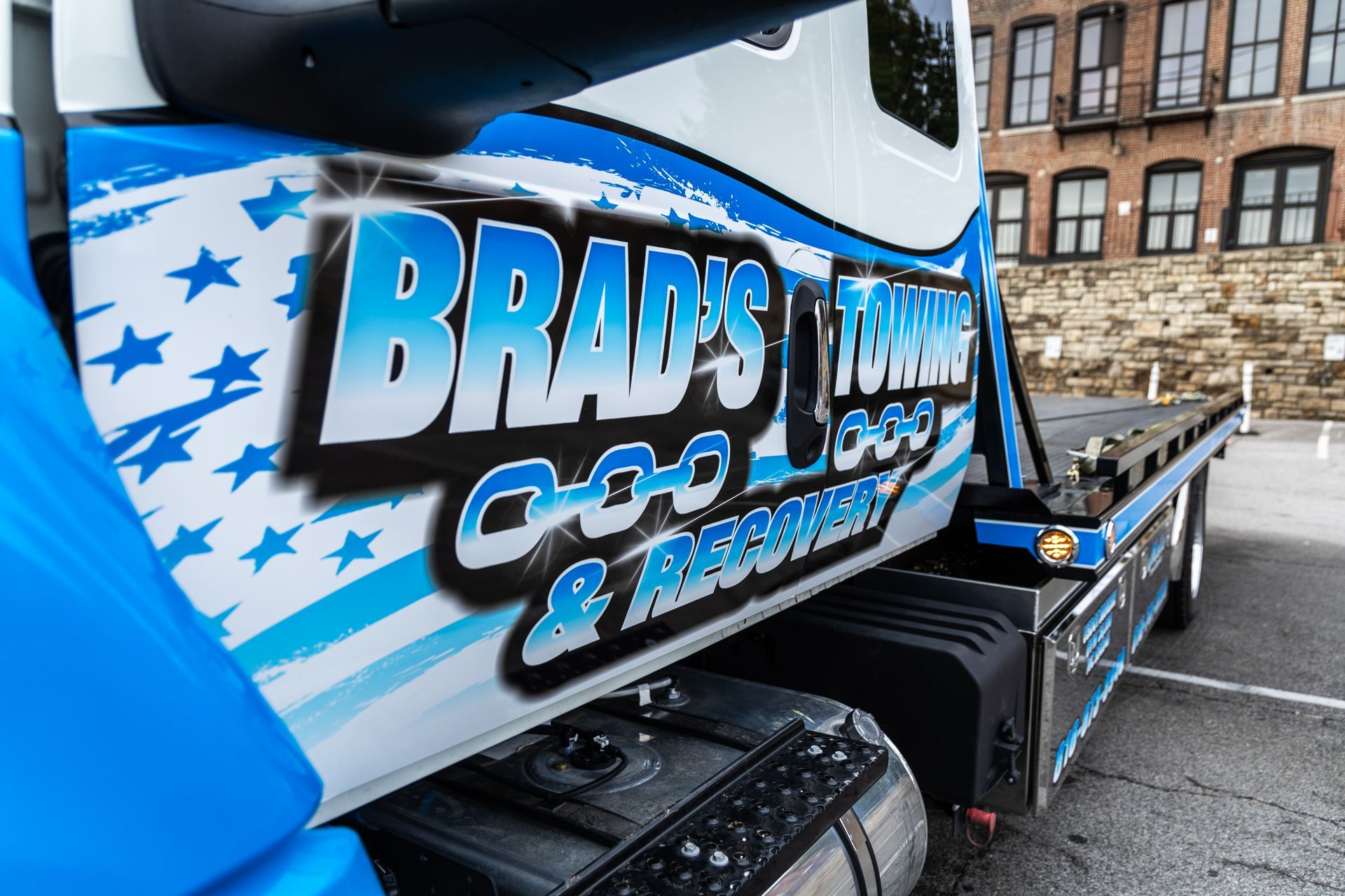 A blue and white tow truck from brad 's towing and recovery
