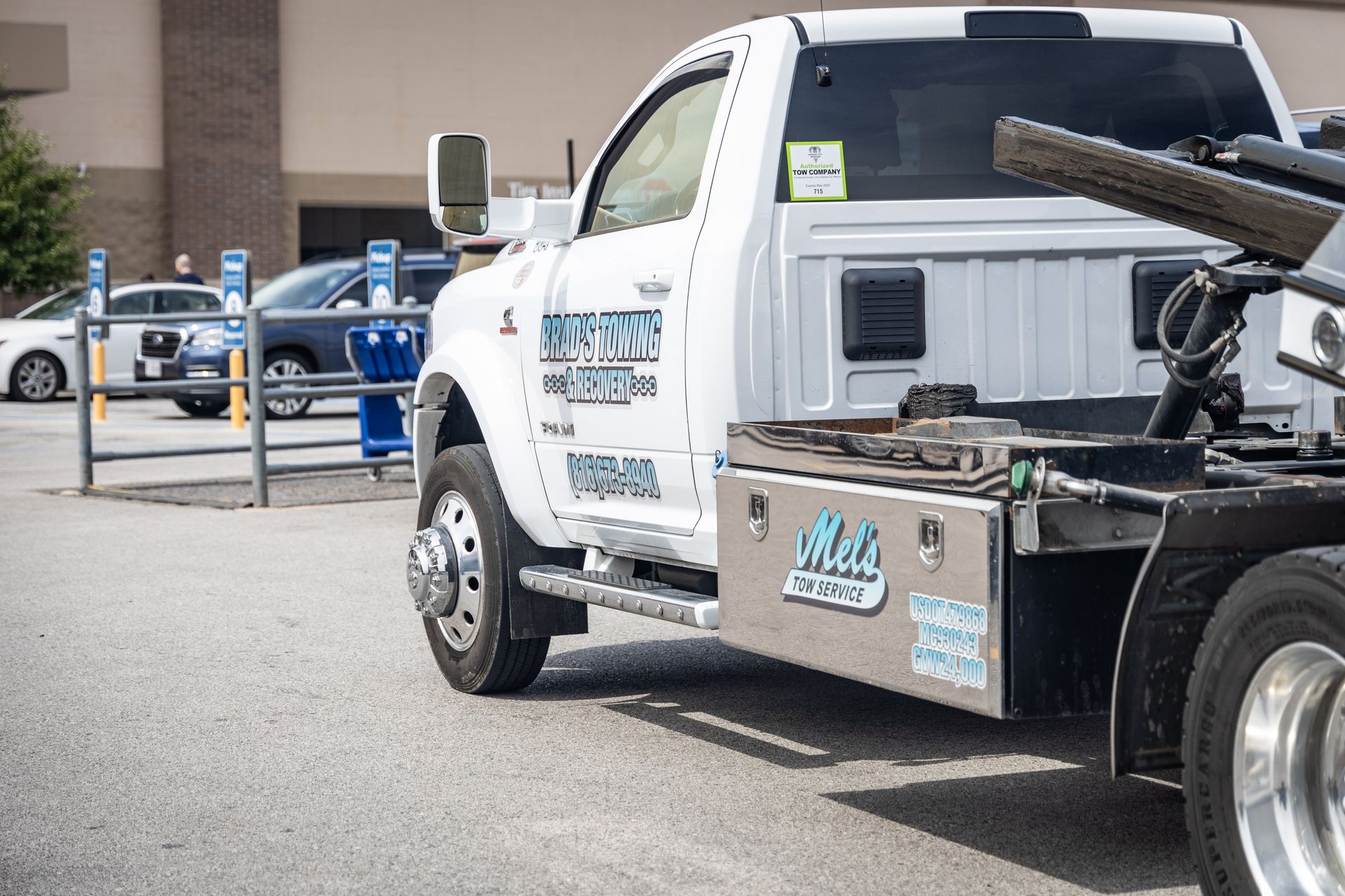 A white tow truck is parked in a parking lot.