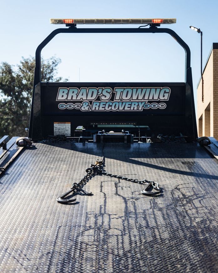 The back of a tow truck with the words brad 's towing on it.