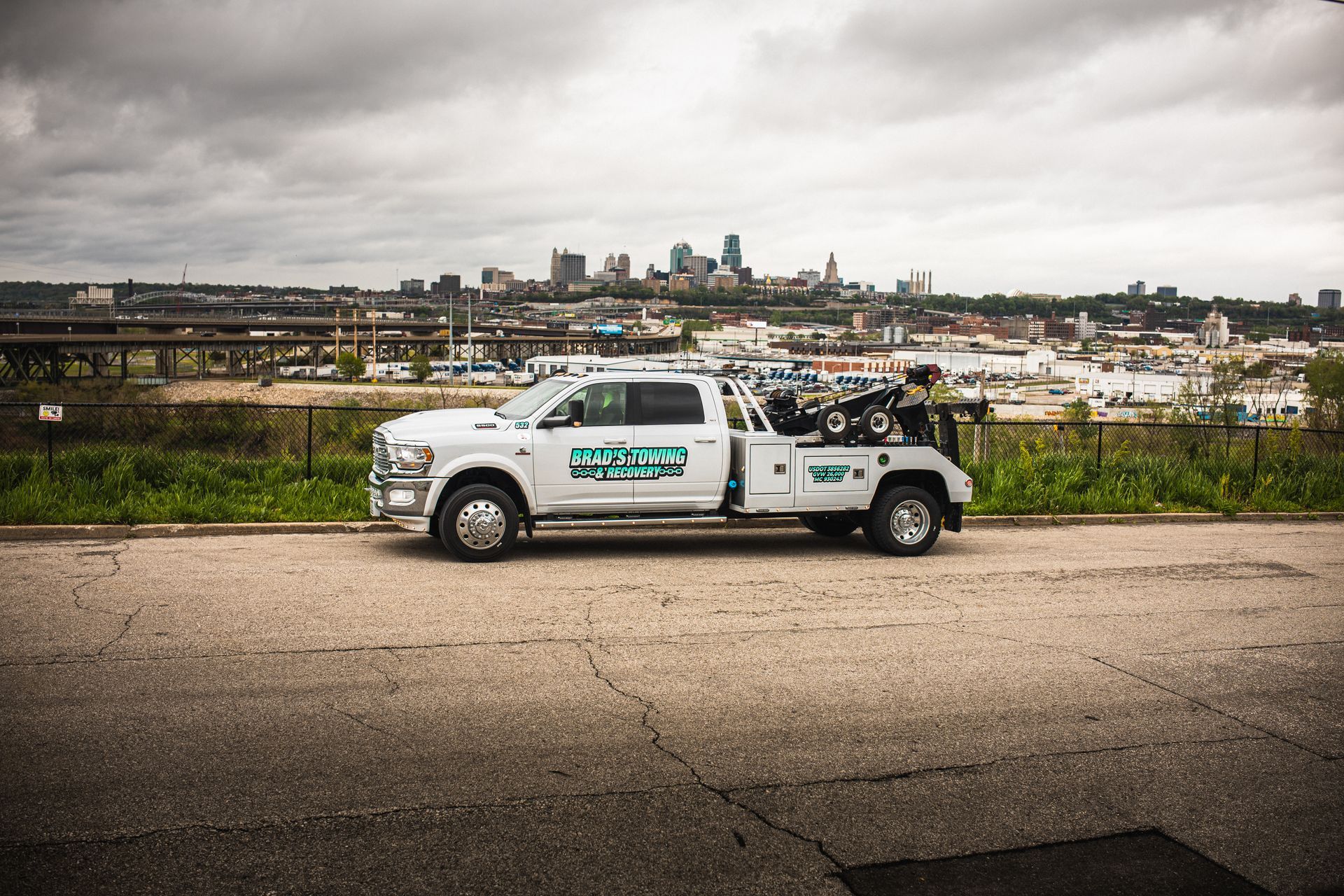 A white tow truck is parked on the side of the road.
