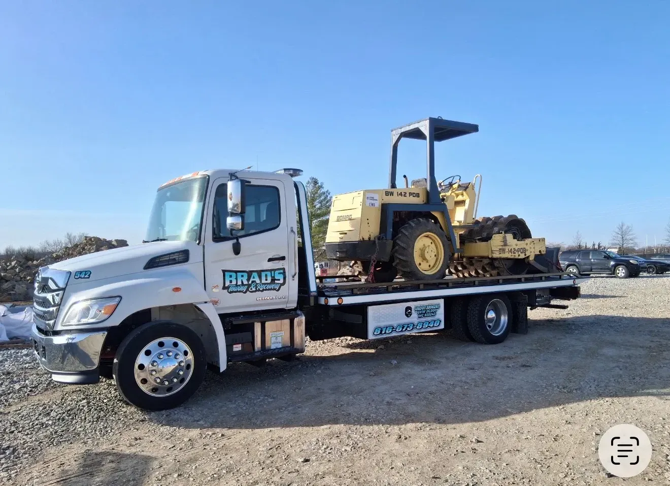 A man is standing in front of a tow truck that says tow truck