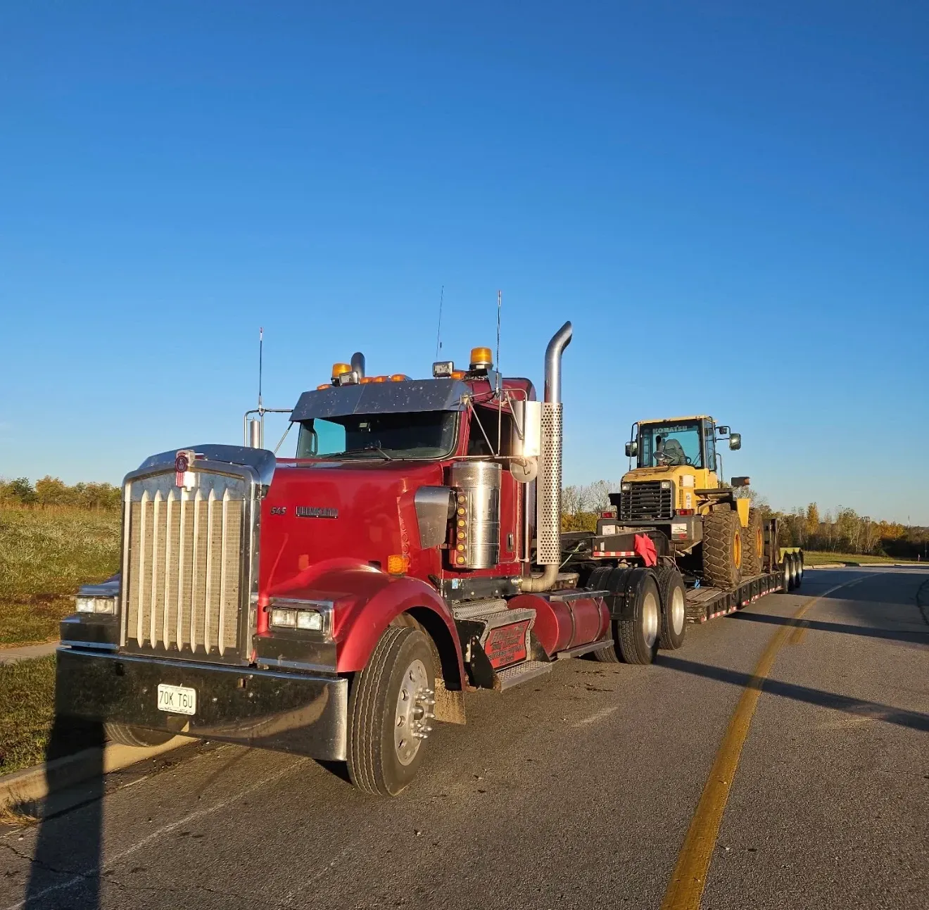 A man is standing in front of a tow truck that says tow truck