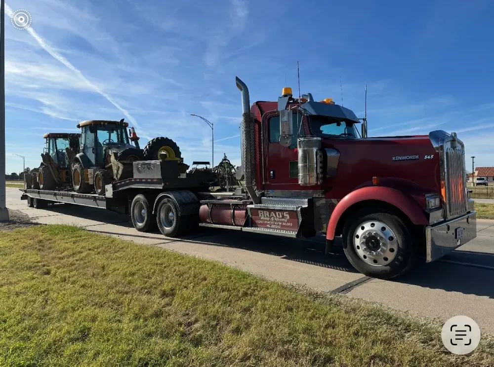 A man is standing in front of a tow truck that says tow truck