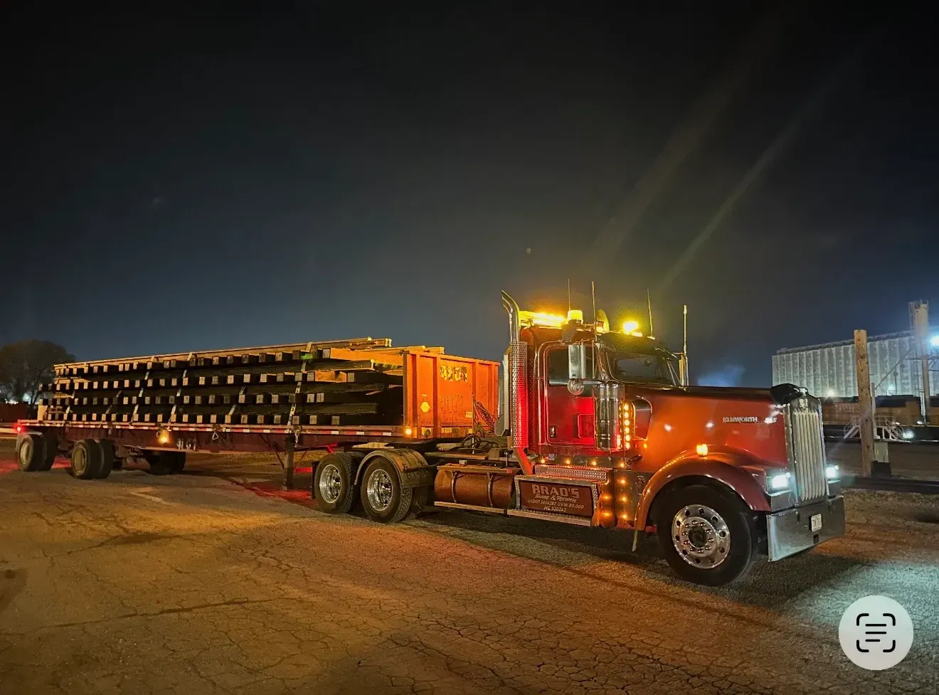 A man is standing in front of a tow truck that says tow truck